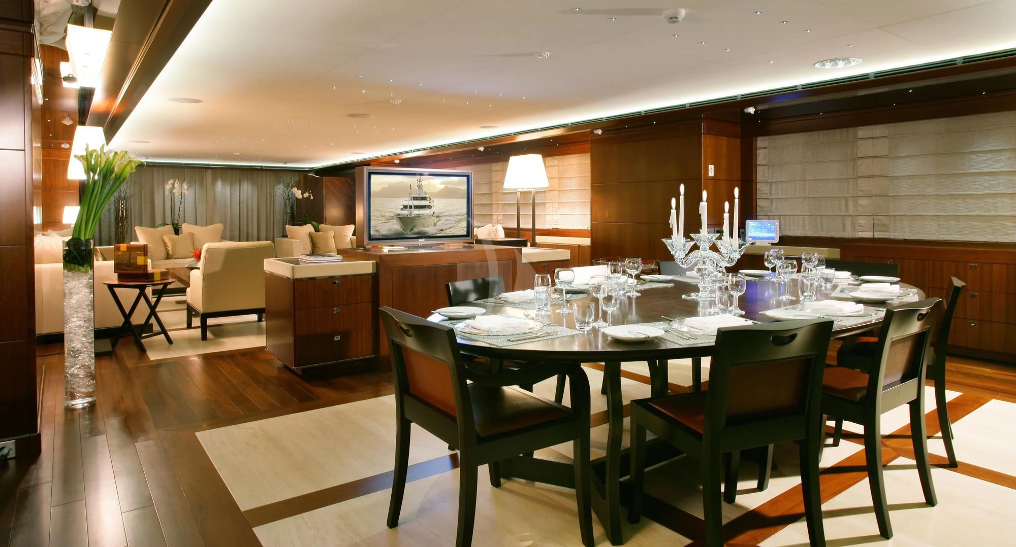 a large dining table in a large room with a large screen aboard MARAYA Yacht for Sale