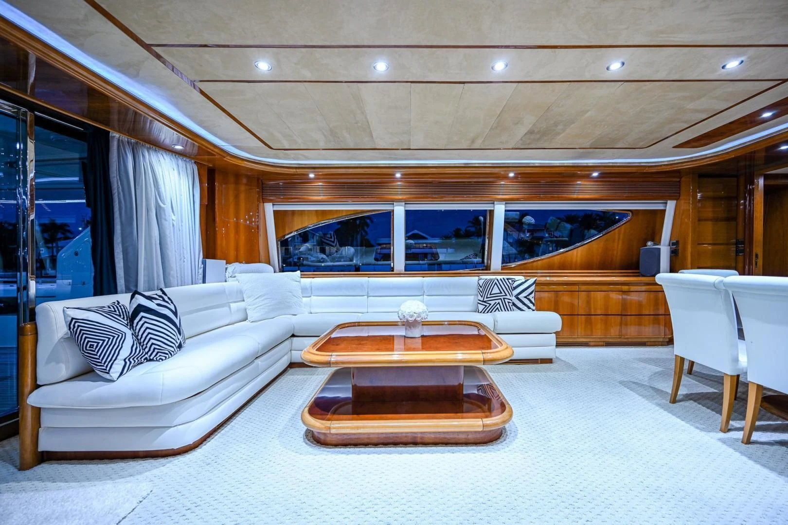 a large living room with a large white couch and a large window aboard EVERYTHING GOOD Yacht for Sale
