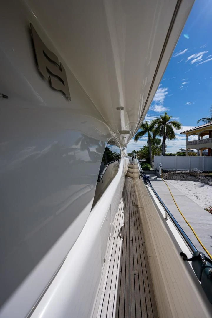 a long white wall with a road and palm trees on the side aboard EVERYTHING GOOD Yacht for Sale