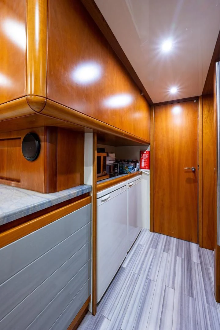a kitchen with wooden cabinets aboard EVERYTHING GOOD Yacht for Sale