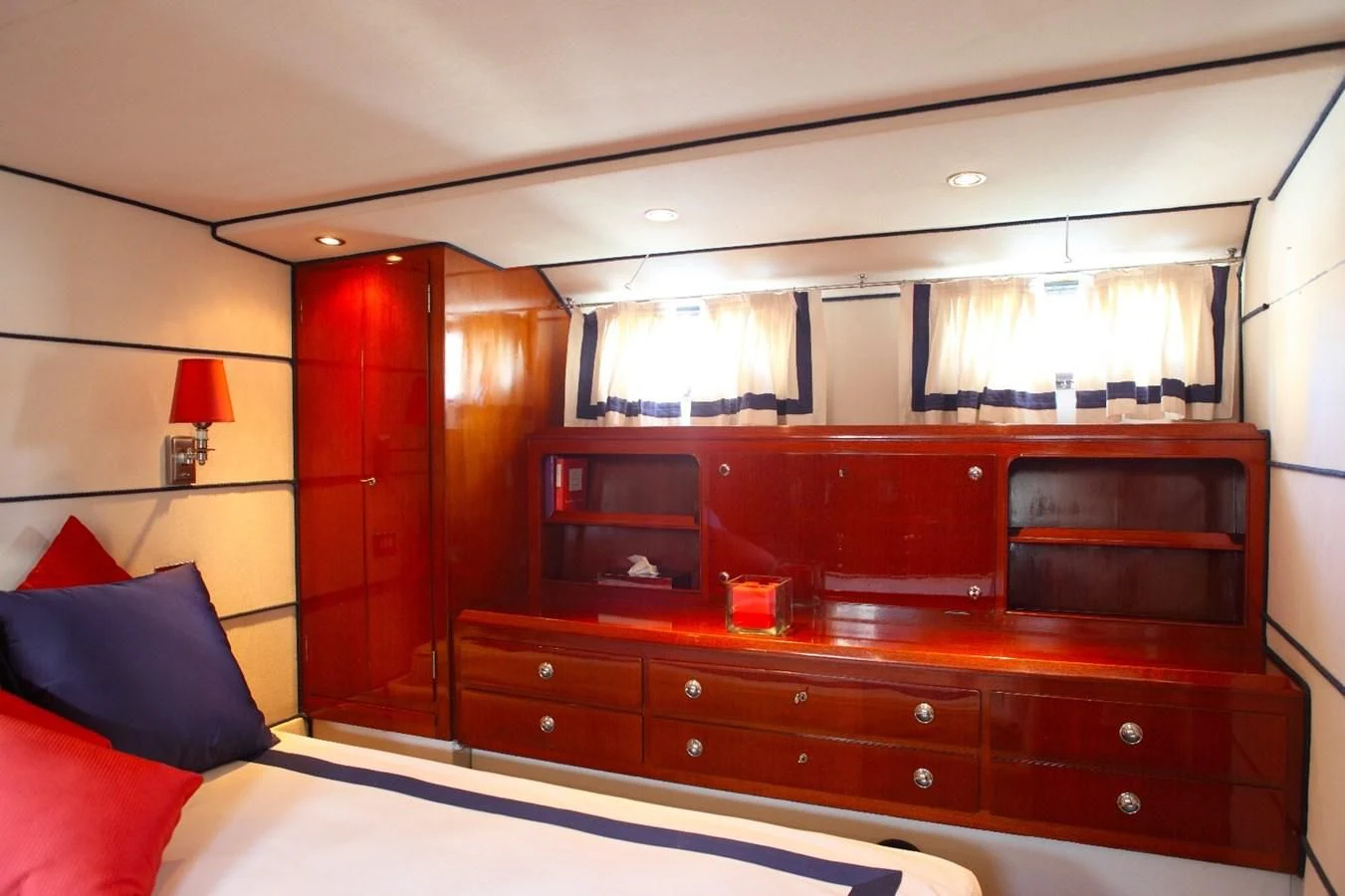 a bedroom with a dresser and a bed aboard UNICA Yacht for Sale