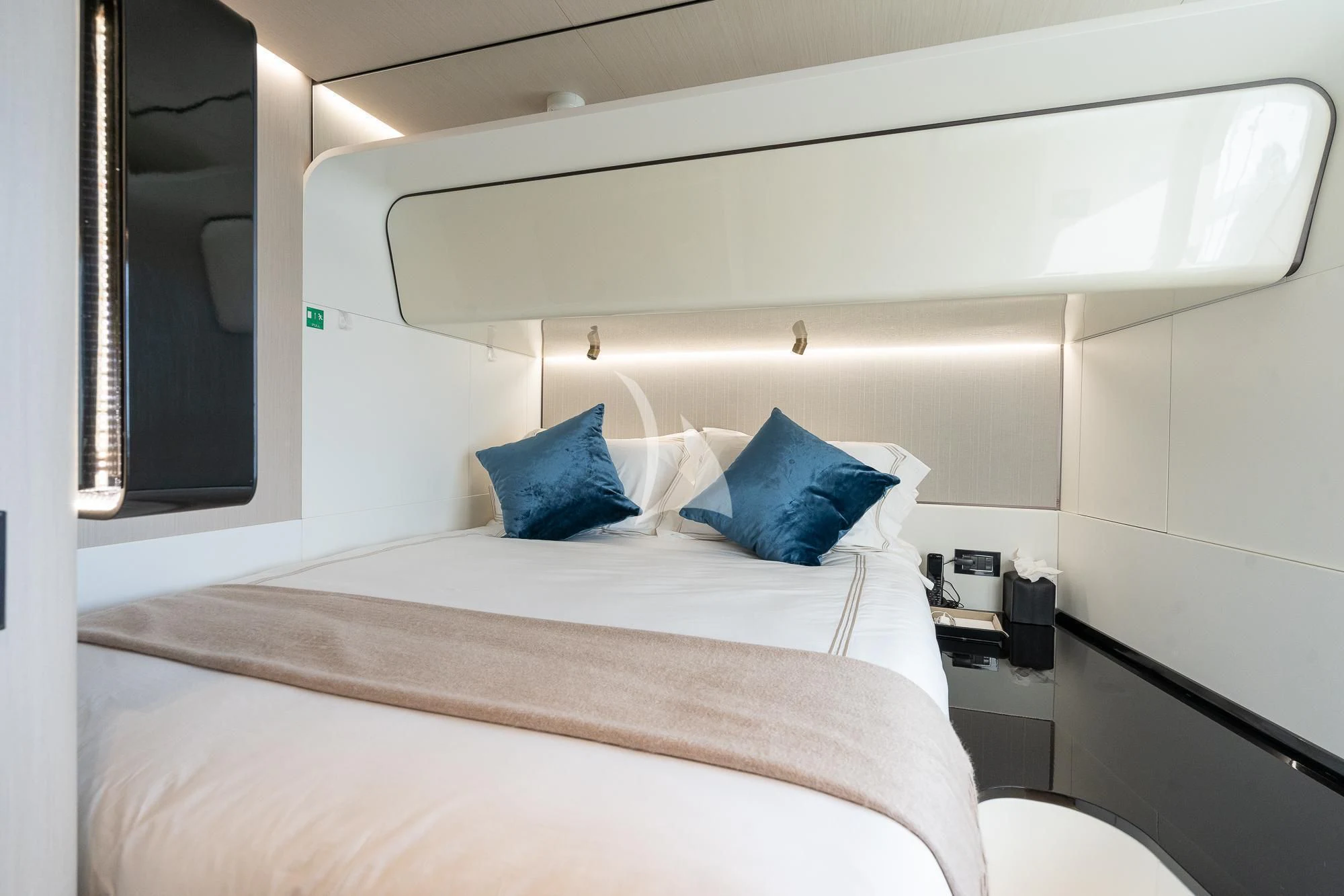 a bed with a white sheet and blue pillows aboard SEA OWL Yacht for Sale