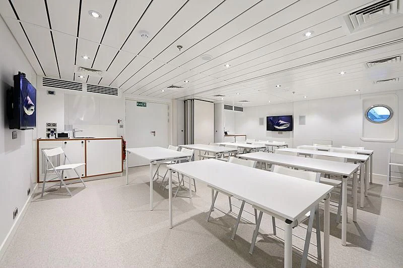 a room with tables and chairs aboard YERSIN Yacht for Charter