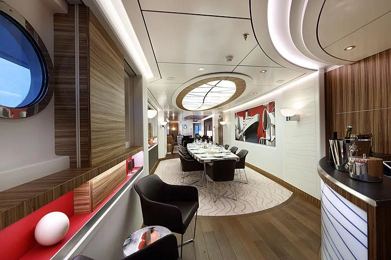 a room with a table chairs and a television aboard YERSIN Yacht for Charter