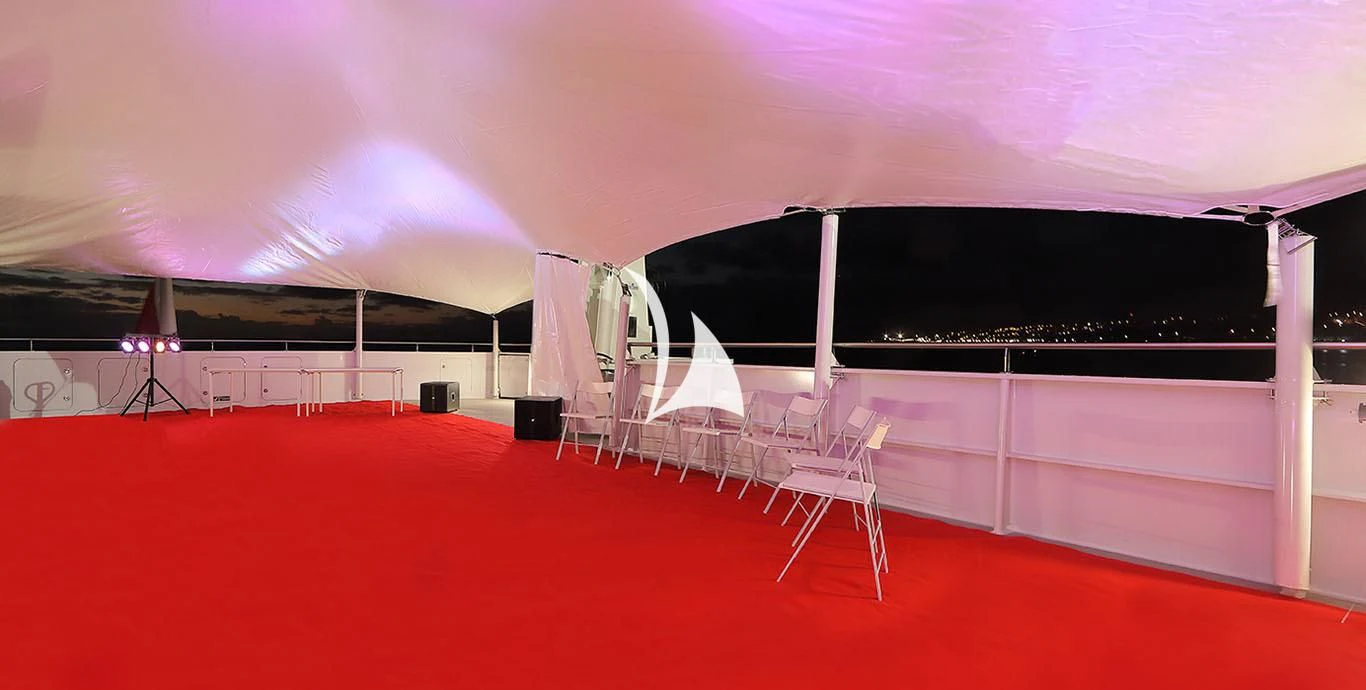 a stage with a red carpet and chairs aboard YERSIN Yacht for Charter