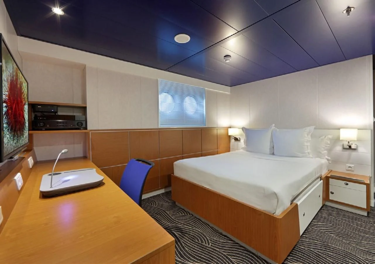 a room with a bed and a desk aboard YERSIN Yacht for Charter