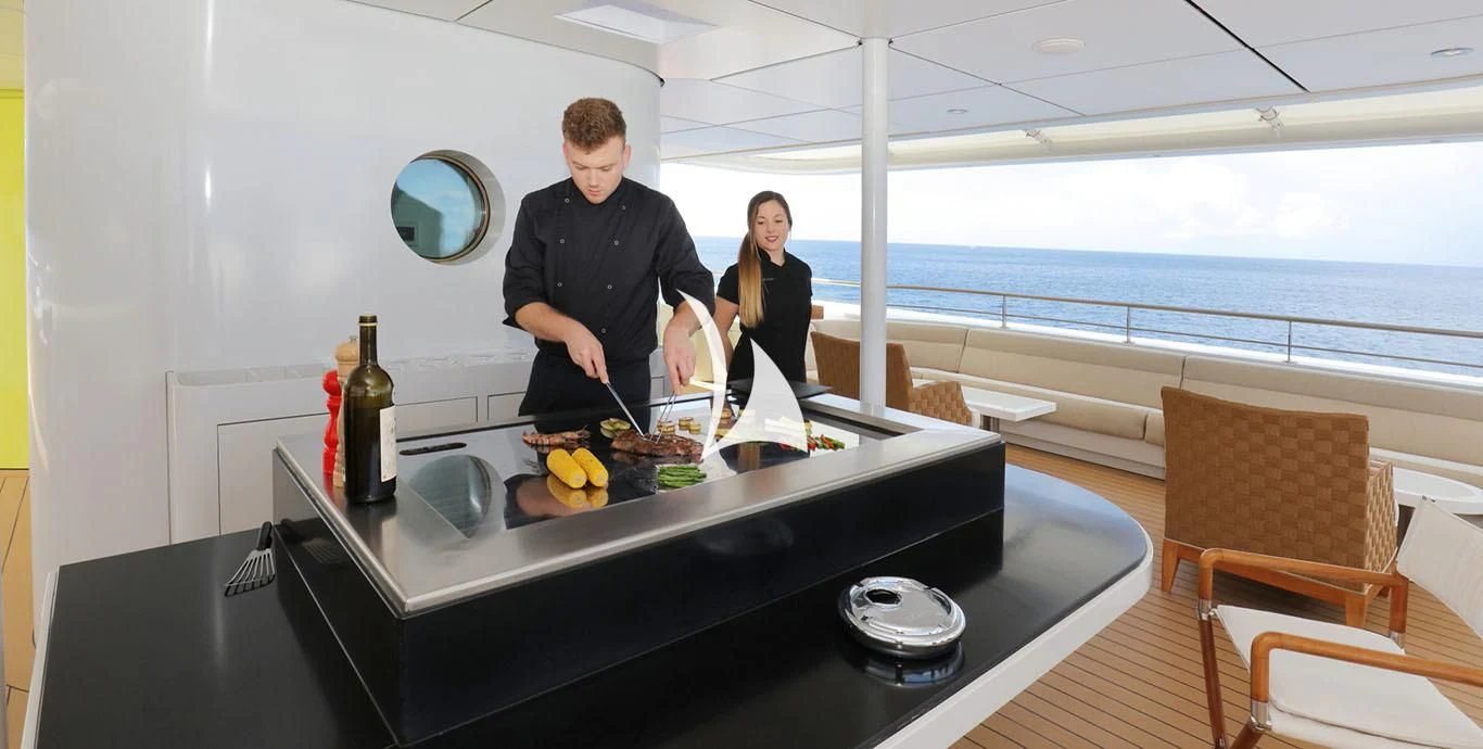a man and woman cooking food on a table aboard YERSIN Yacht for Charter
