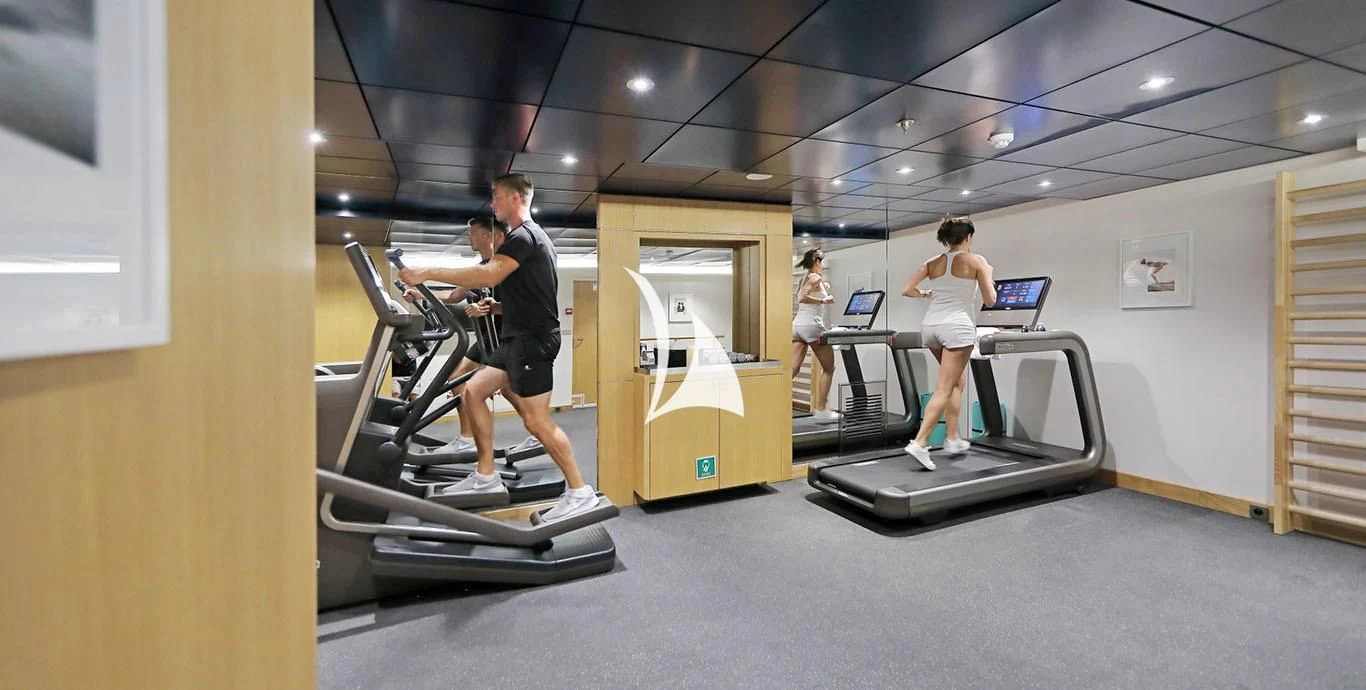 a man and woman exercising in a gym aboard YERSIN Yacht for Charter