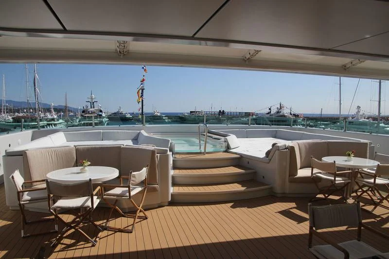 a deck with tables and chairs aboard YERSIN Yacht for Charter