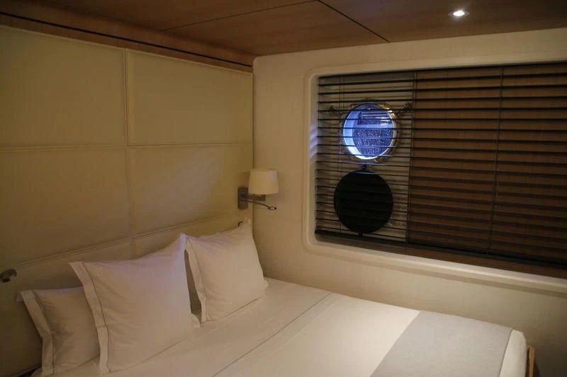 a bed with a white bed spread aboard YERSIN Yacht for Charter