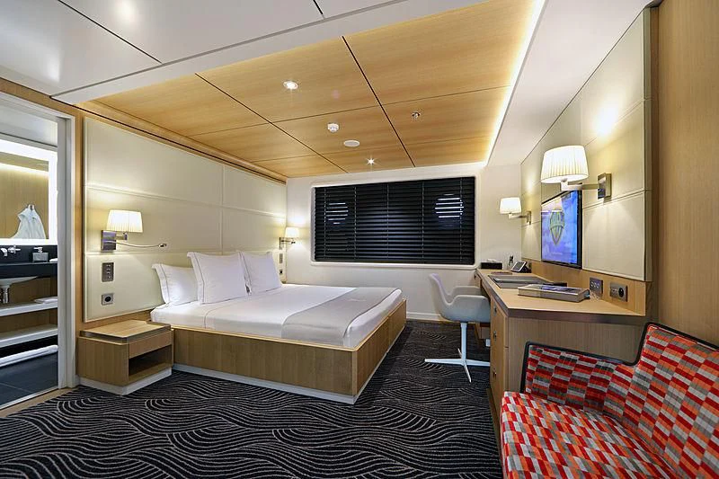 a hotel room with a bed and a desk aboard YERSIN Yacht for Charter