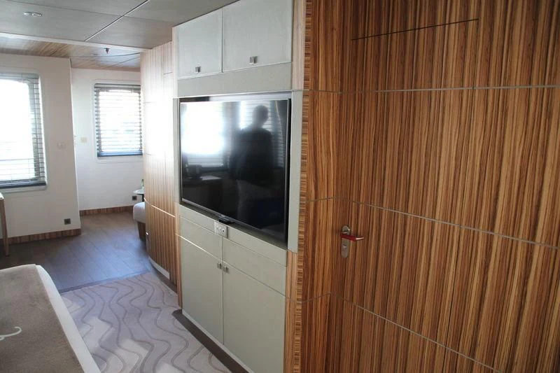a room with a tv and a wood wall aboard YERSIN Yacht for Charter