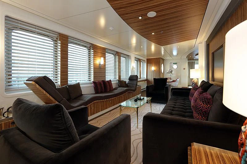 a living room with leather couches and a large window aboard YERSIN Yacht for Charter