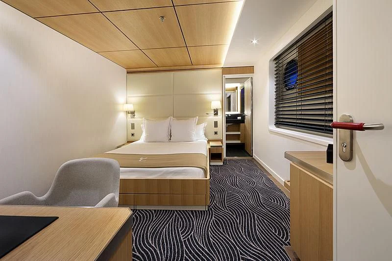 a room with a bed and a desk aboard YERSIN Yacht for Charter