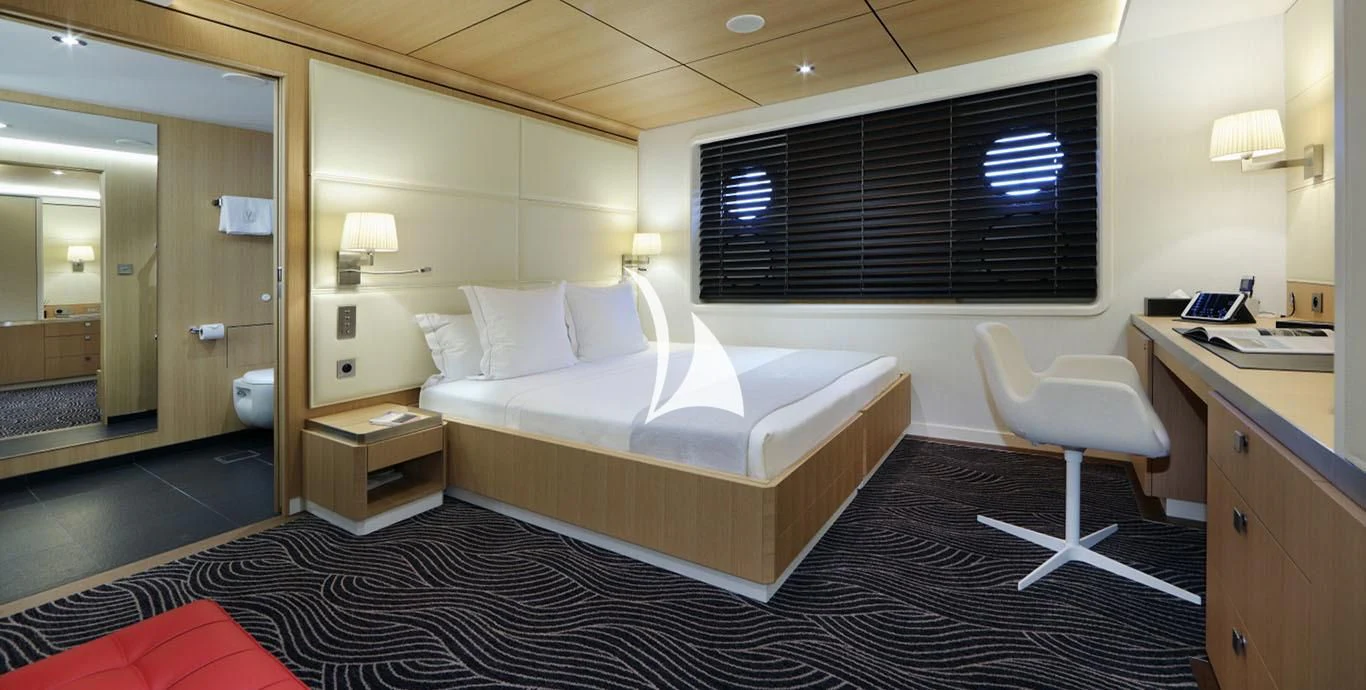 a hotel room with a bed and desk aboard YERSIN Yacht for Charter