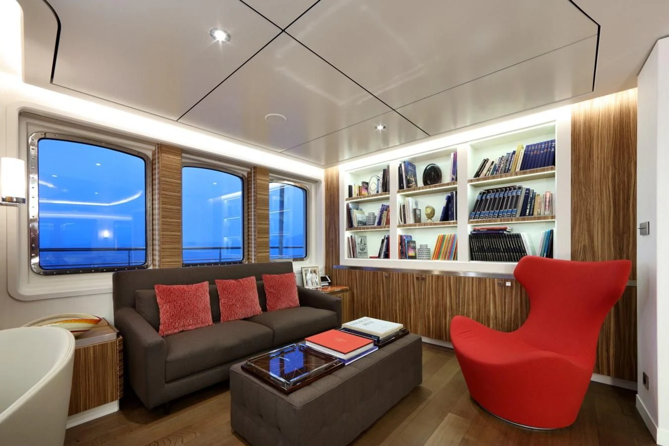 a living room with a red chair aboard YERSIN Yacht for Charter