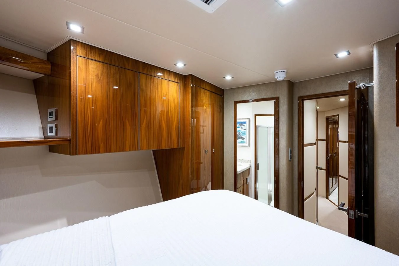 a large room with a large white bed and wooden cabinets aboard ABSOLUT Yacht for Sale