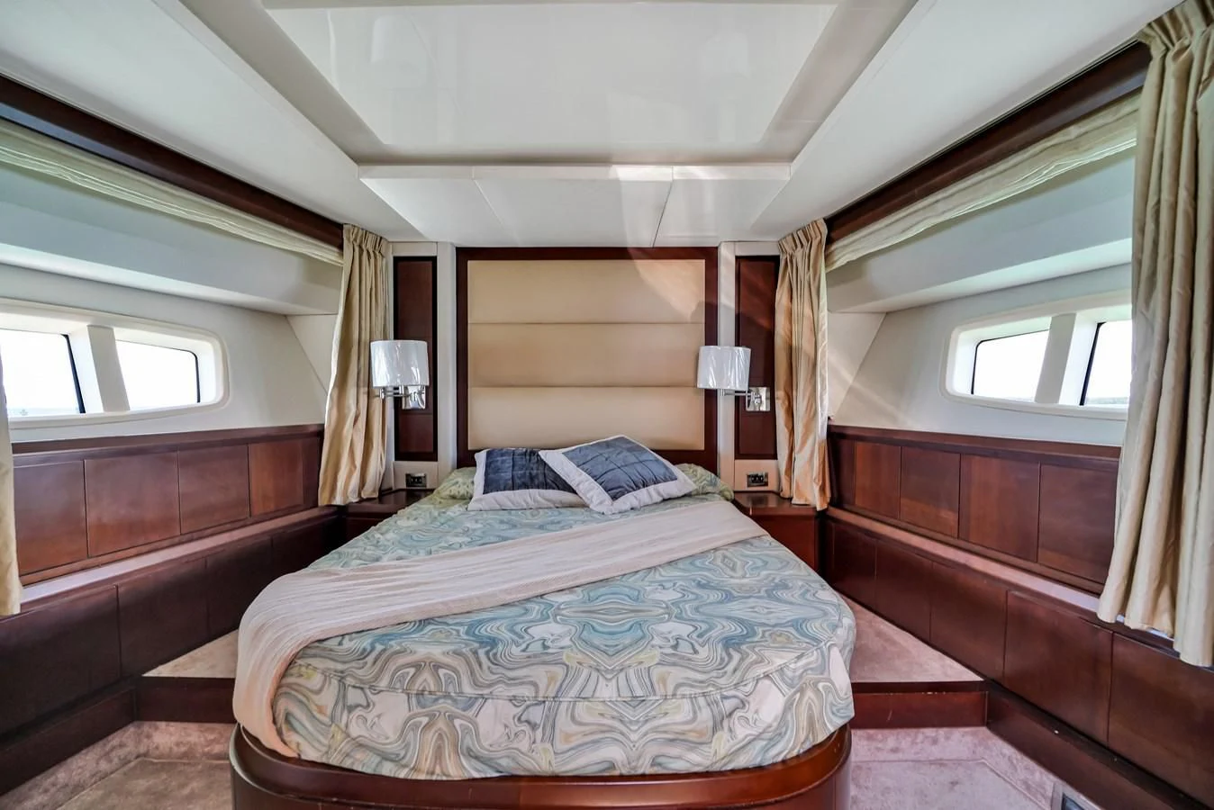 a bedroom with a bed and a window aboard TABATA Yacht for Sale