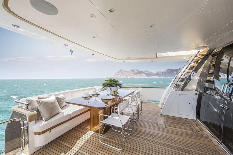 a balcony with a table and chairs aboard NICOSTASIA Yacht for Sale