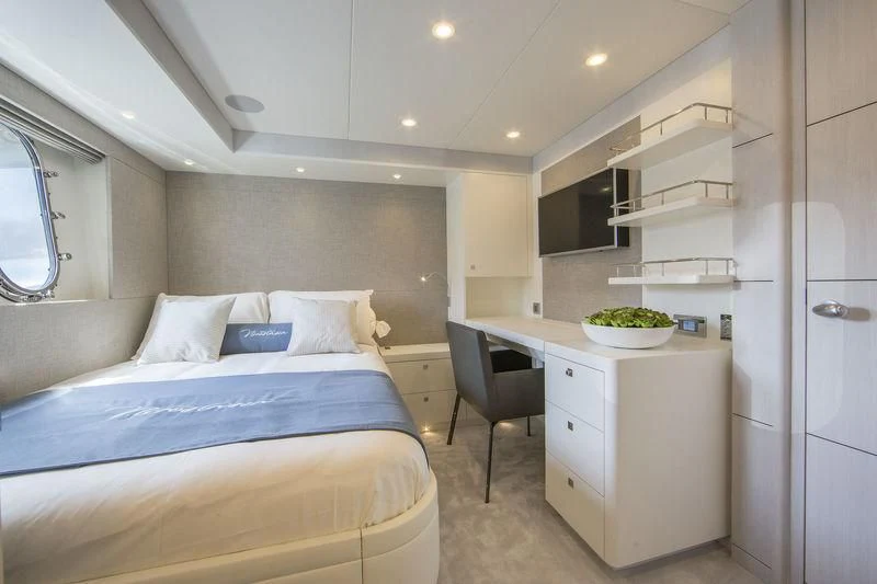a bedroom with a bed and a desk aboard NICOSTASIA Yacht for Sale