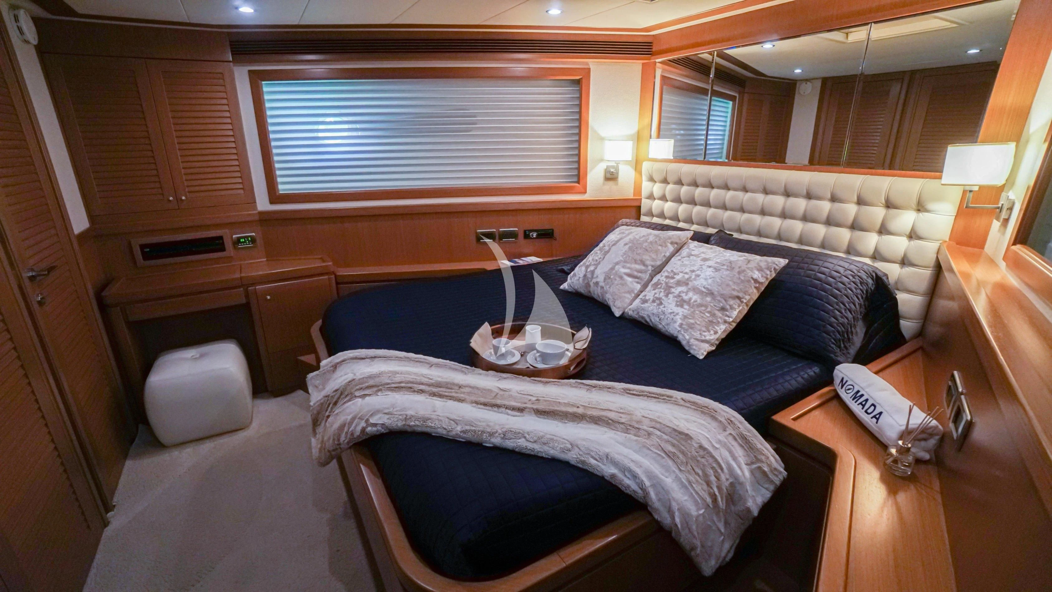 a bed with a blue comforter aboard NOMADA Yacht for Charter