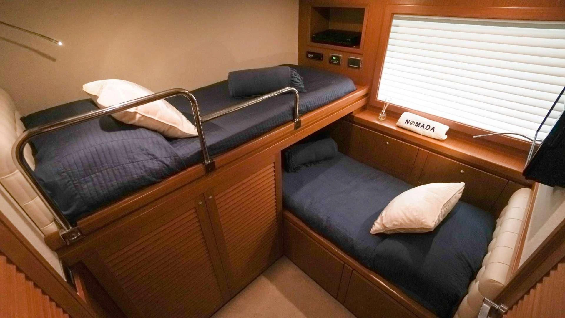 a bed with a blue blanket aboard NOMADA Yacht for Charter