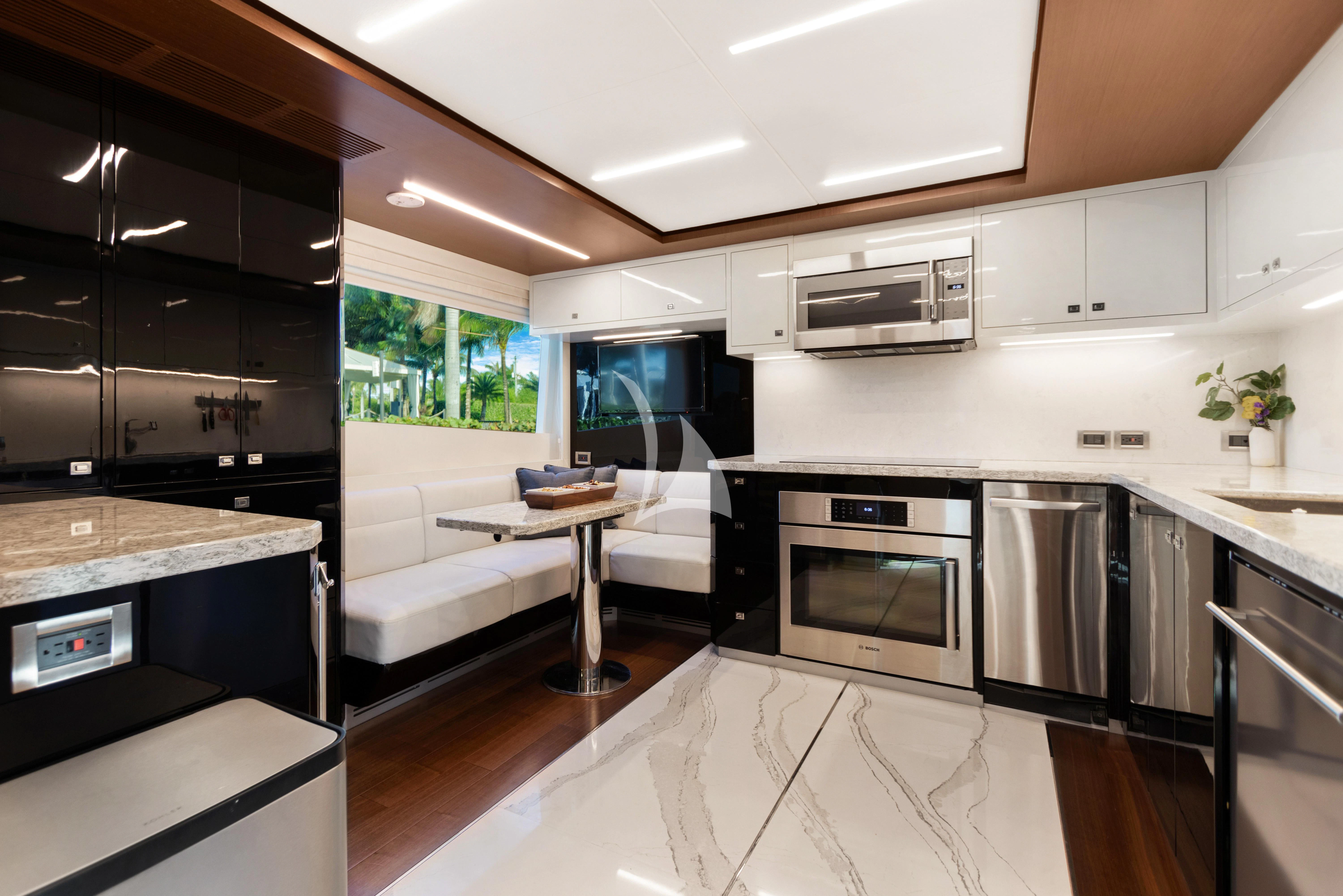 a modern kitchen with black and white appliances aboard MAKE BIG HAPPEN Yacht for Sale