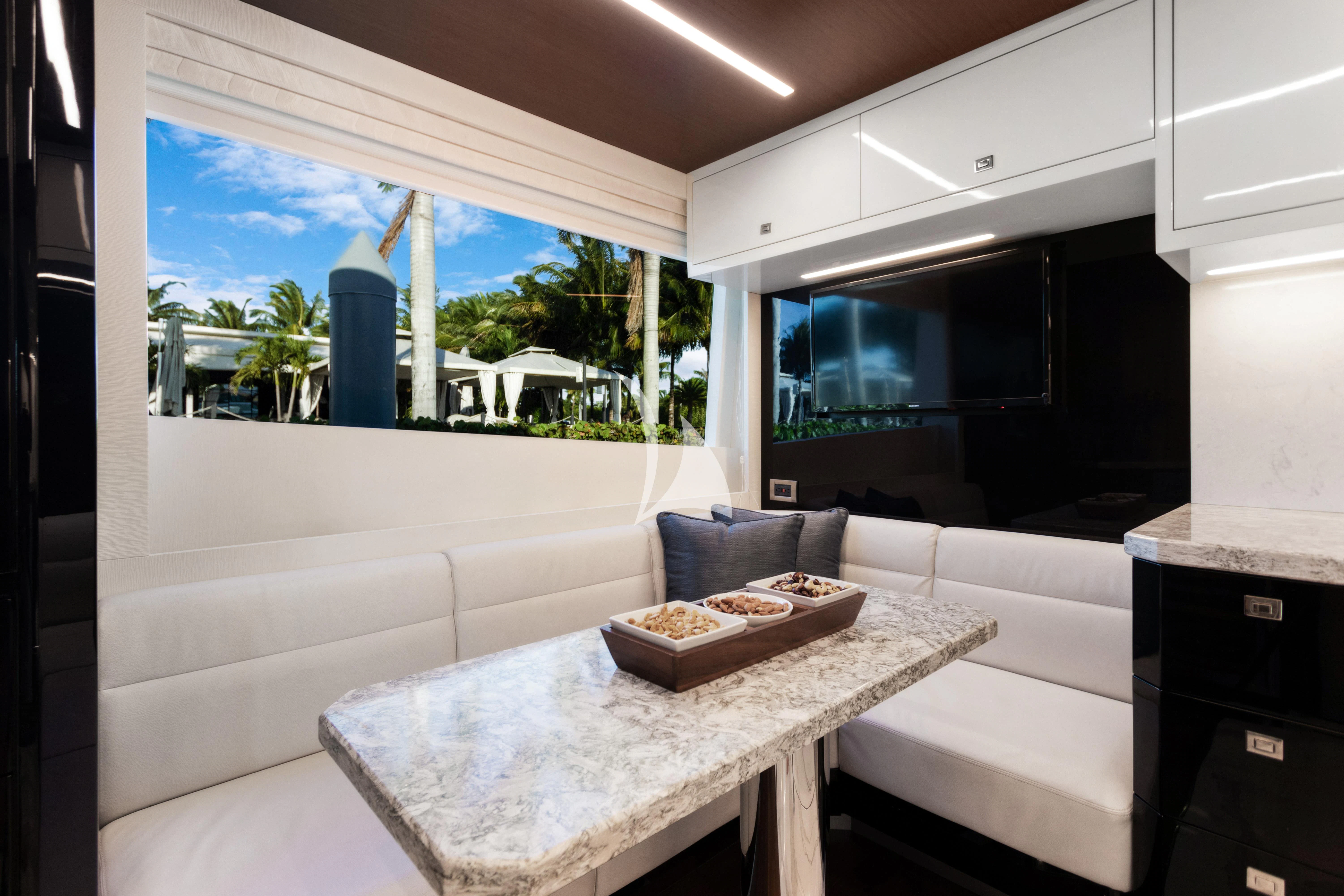 a room with a table and a couch aboard MAKE BIG HAPPEN Yacht for Sale