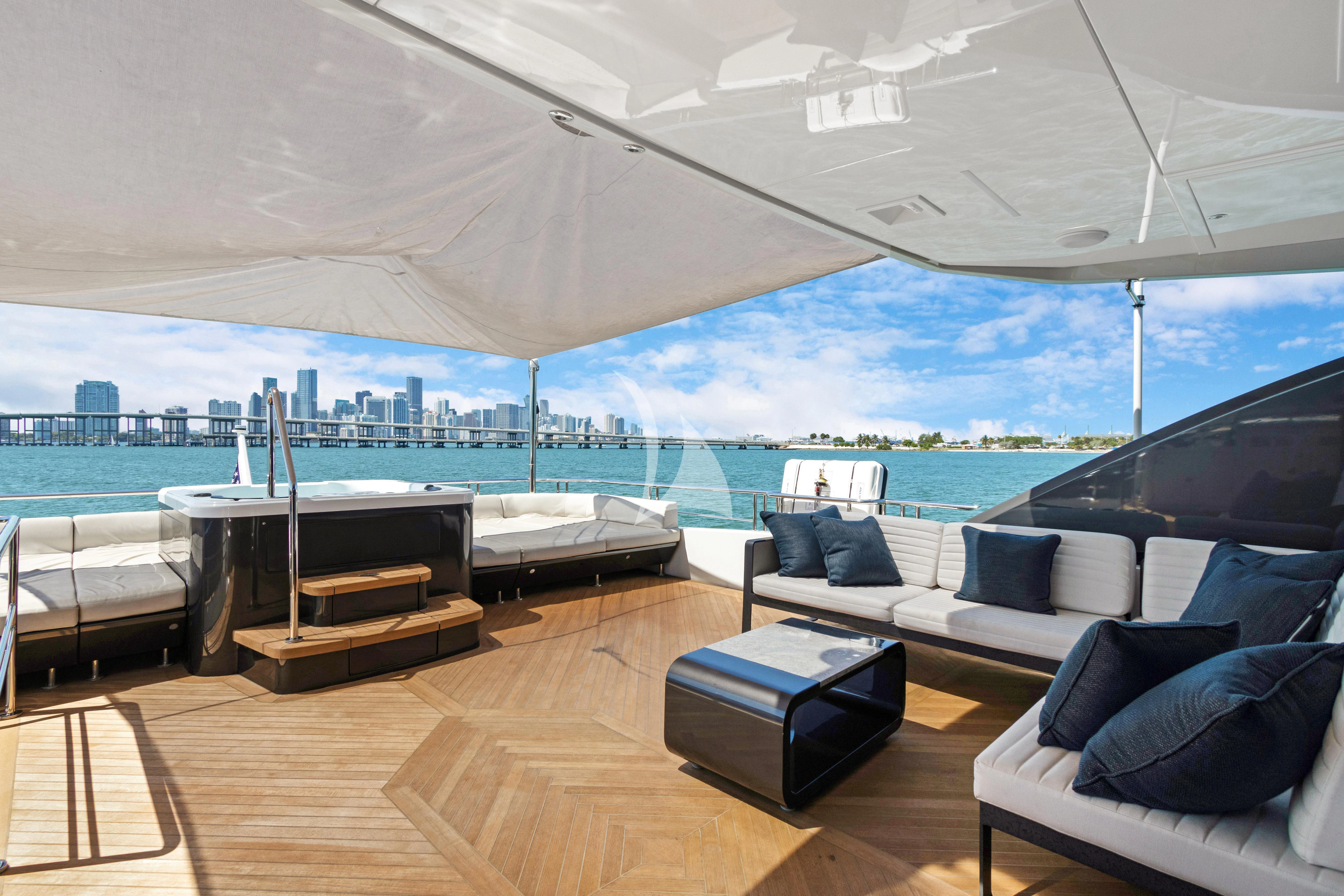a room with a couch and a table and a large body of water aboard MAKE BIG HAPPEN Yacht for Sale