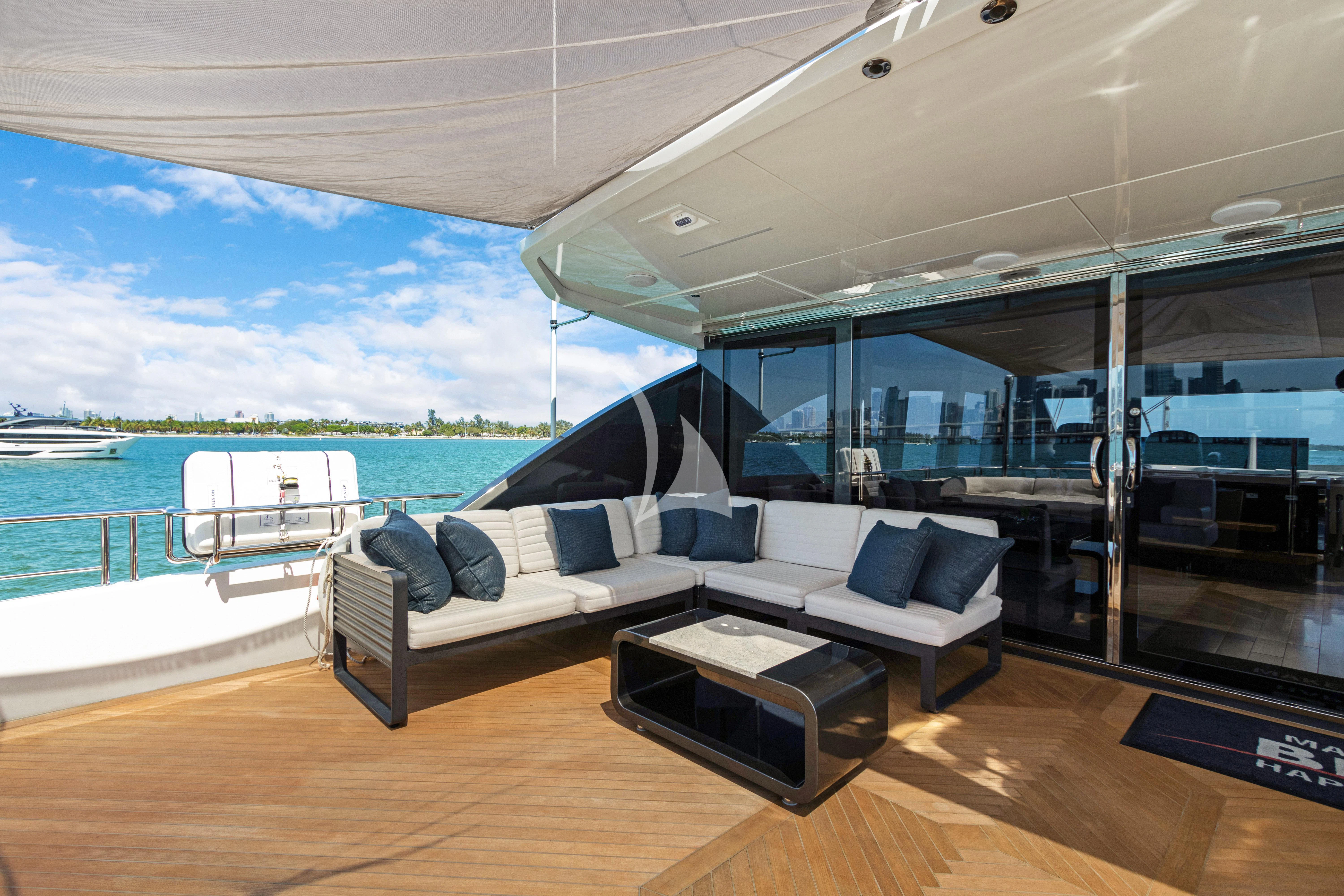 a room with a couch and a table on a deck aboard MAKE BIG HAPPEN Yacht for Sale