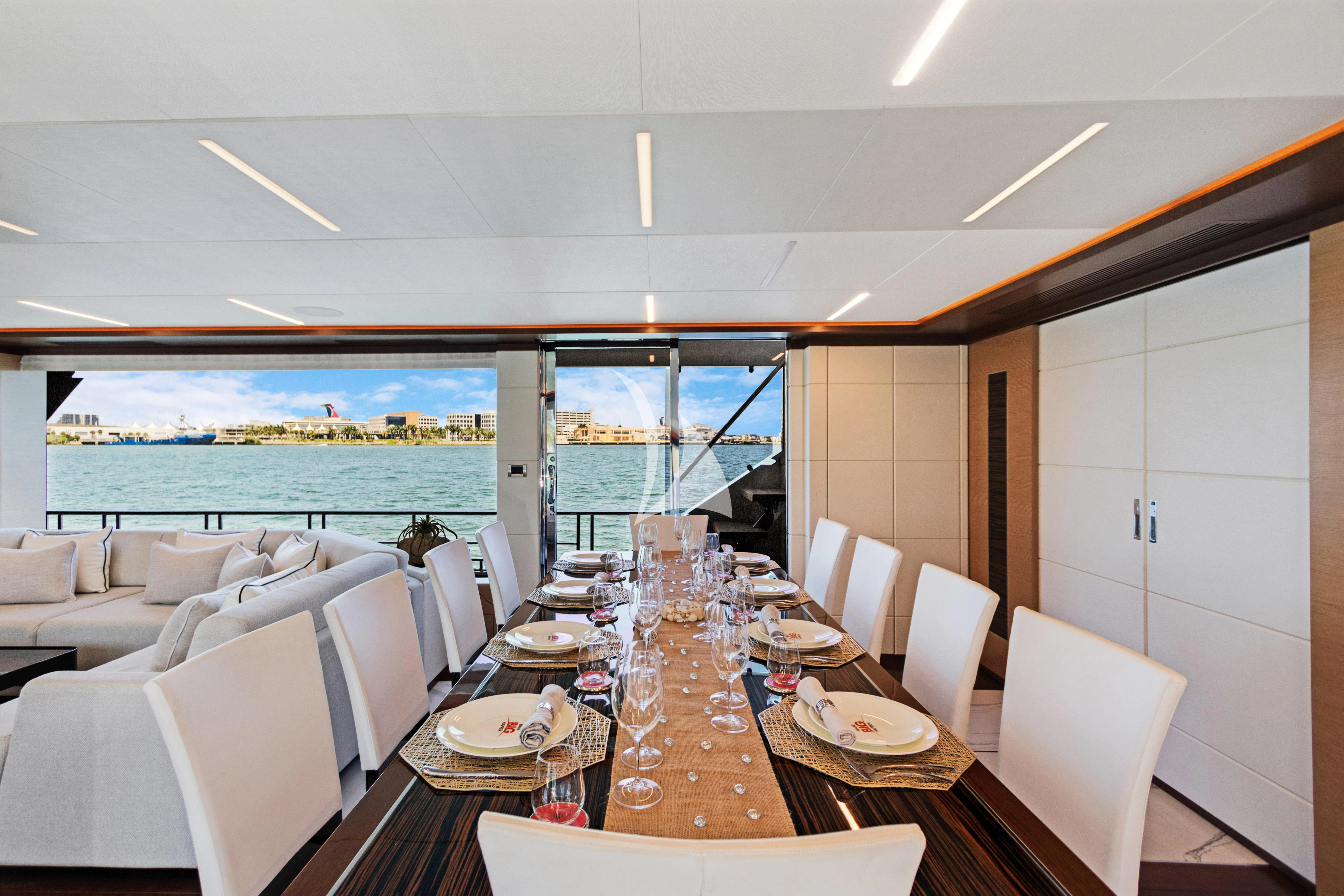 a dining room with a large window aboard MAKE BIG HAPPEN Yacht for Sale