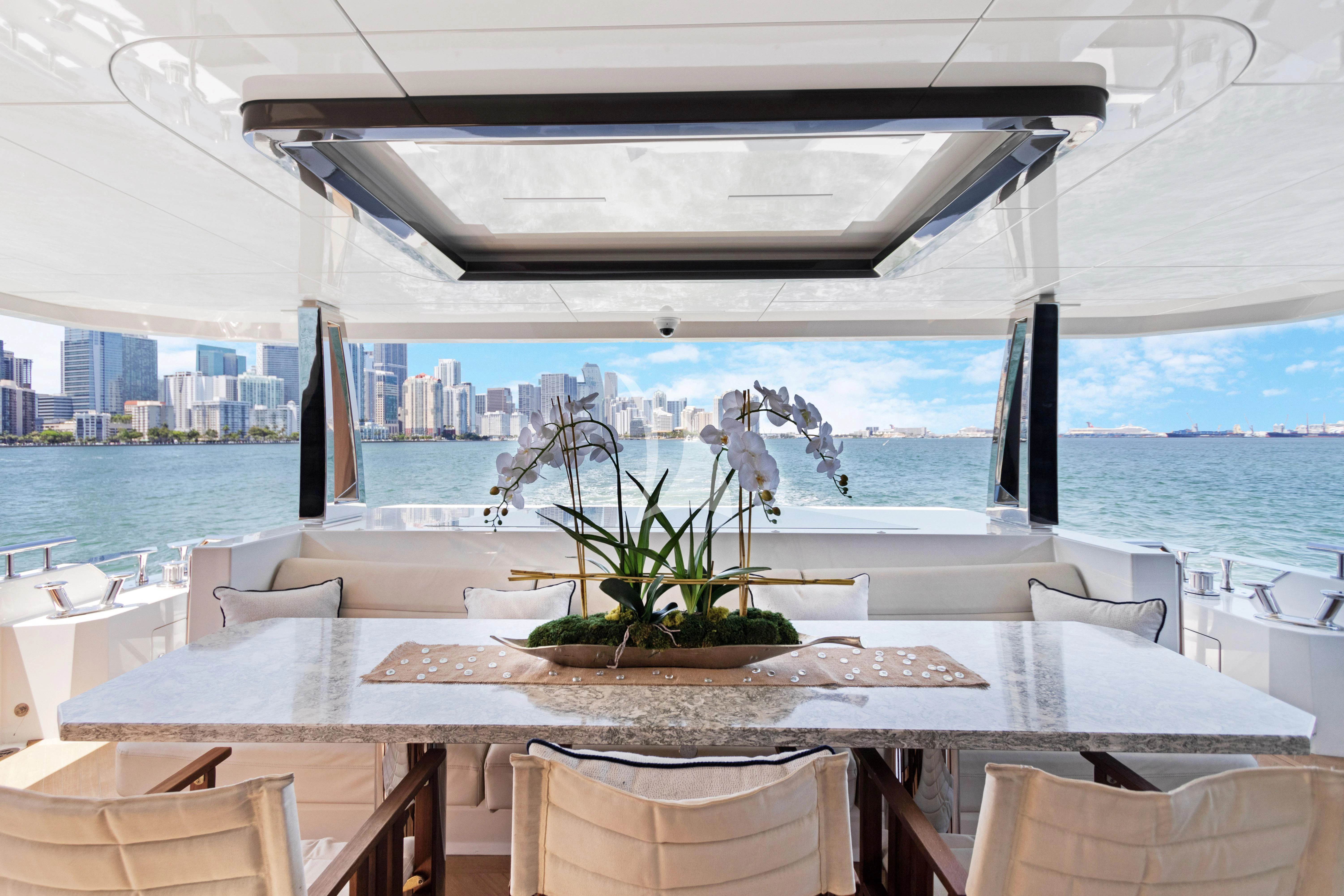 a table with chairs and a plant on it aboard MAKE BIG HAPPEN Yacht for Sale