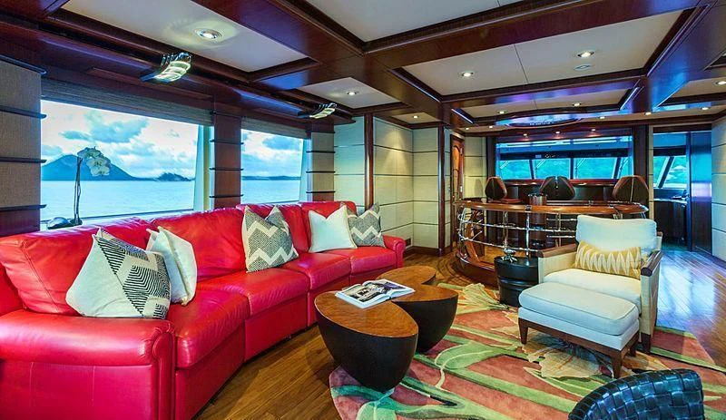a living room with a red couch and a table aboard USHER Yacht for Sale