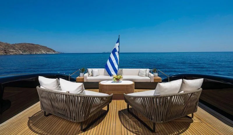 a table with chairs and a large body of water in the background aboard SAINT Yacht for Sale