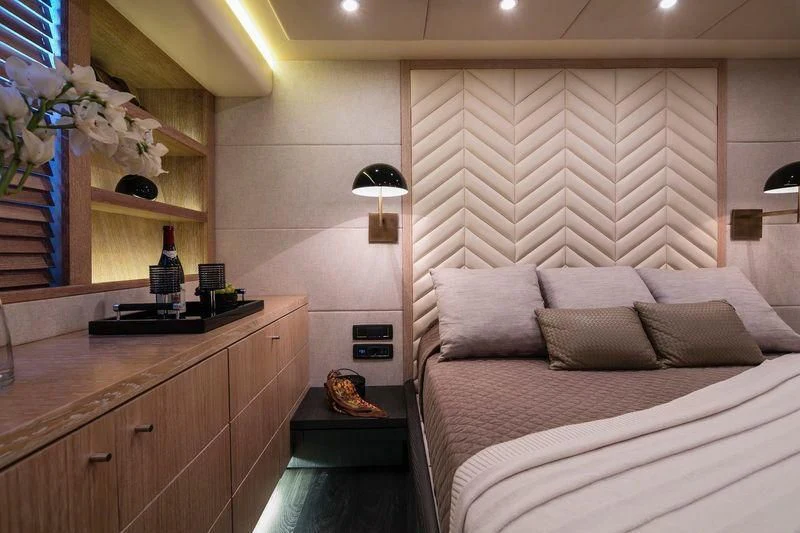 a room with a bed and a shelf with a lamp aboard SAINT Yacht for Sale