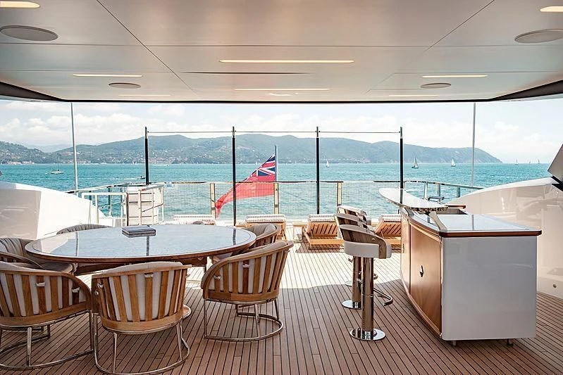 a table and chairs in a room with a view of the ocean aboard LADY LENA Yacht for Sale