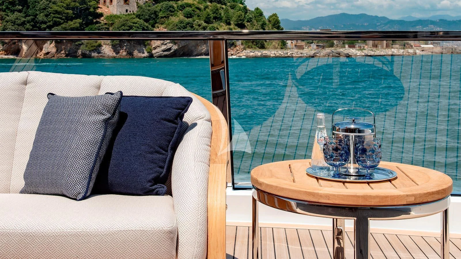 a table with a glass of water and a view of a city aboard LADY LENA Yacht for Sale