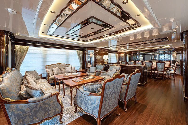 a large living room with a large dining table aboard LADY LENA Yacht for Sale