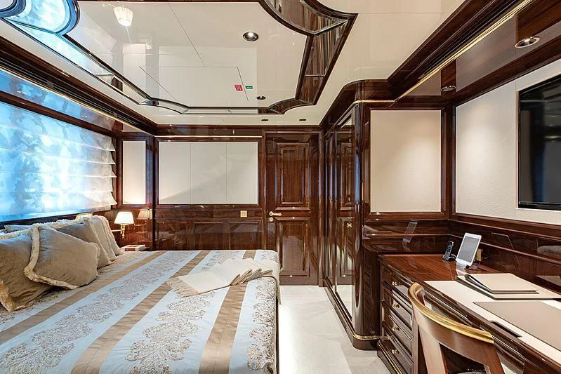 a room with a bed and desk aboard LADY LENA Yacht for Sale