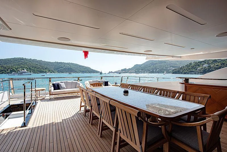 a deck with tables and chairs on it aboard LADY LENA Yacht for Sale