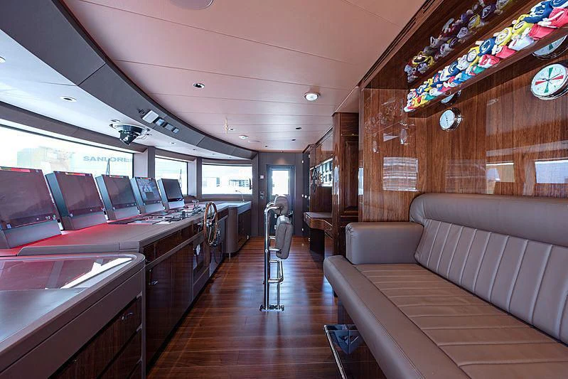 a room with a couch and a table with chairs and a television aboard LADY LENA Yacht for Sale