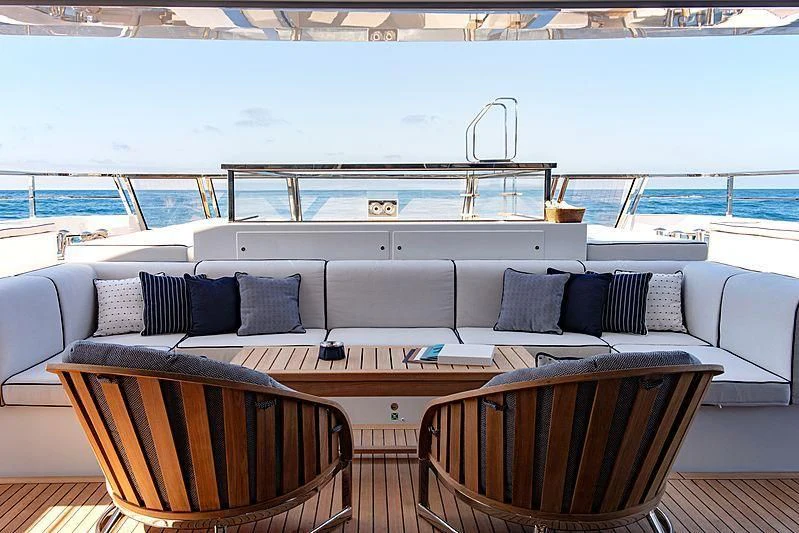 a couch and a table on a deck overlooking a large body of water aboard LADY LENA Yacht for Sale