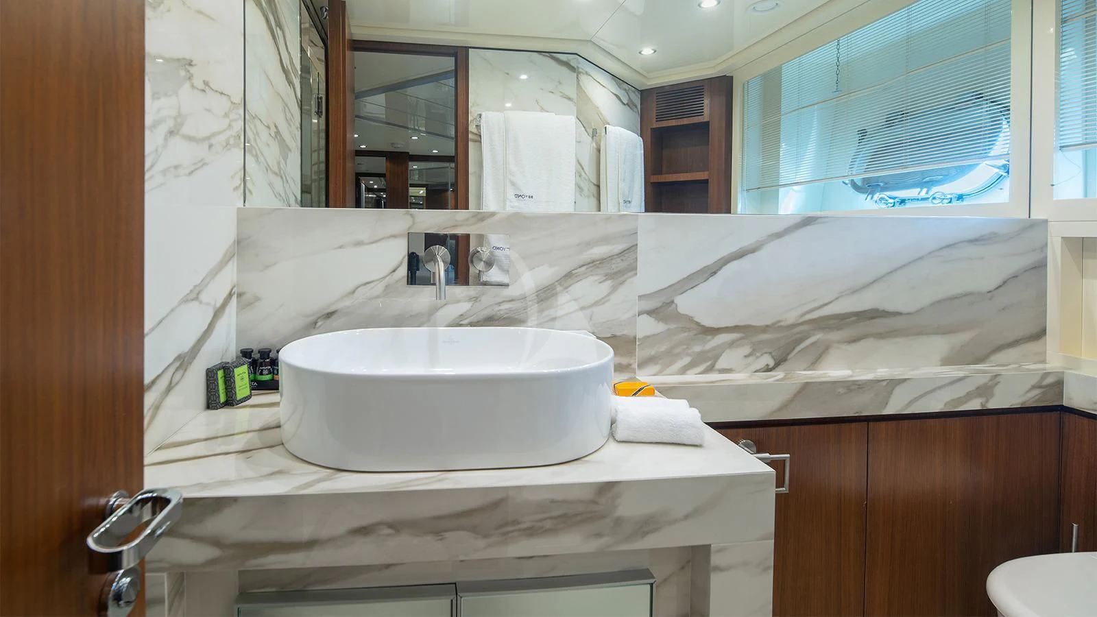a bathroom with a sink and a large mirror aboard BEYOND Yacht for Charter