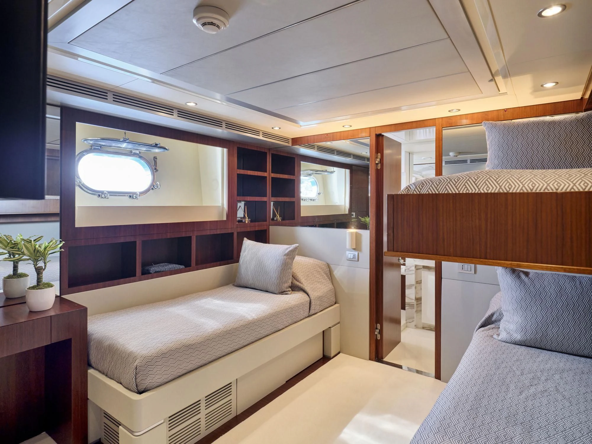 a room with a bed and a television aboard BEYOND Yacht for Charter