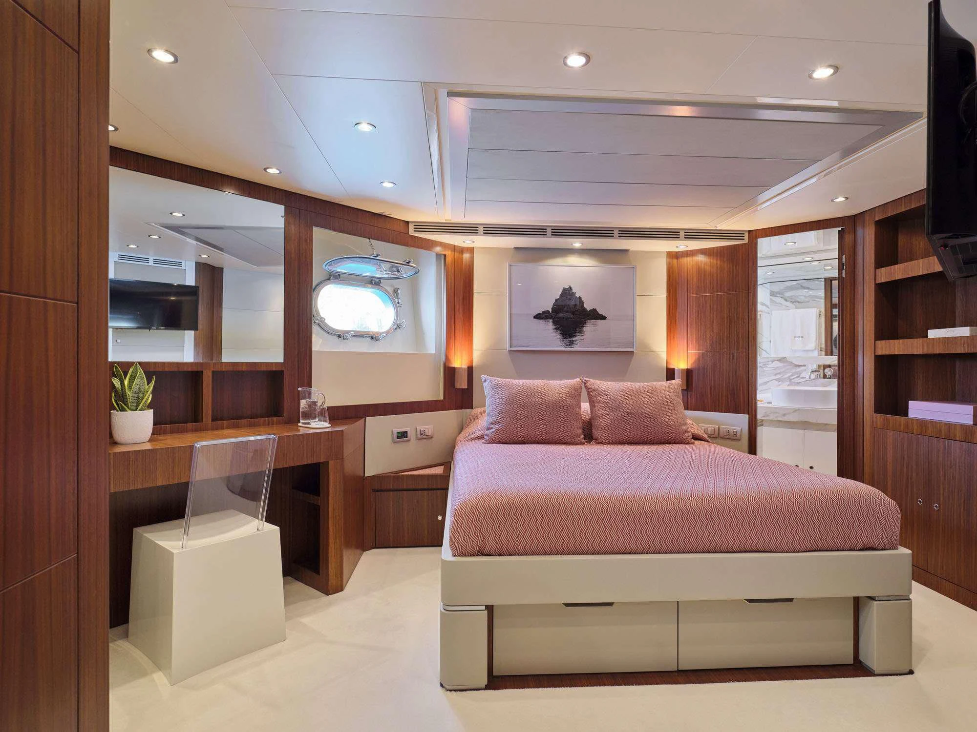 a room with a bed and a desk aboard BEYOND Yacht for Charter