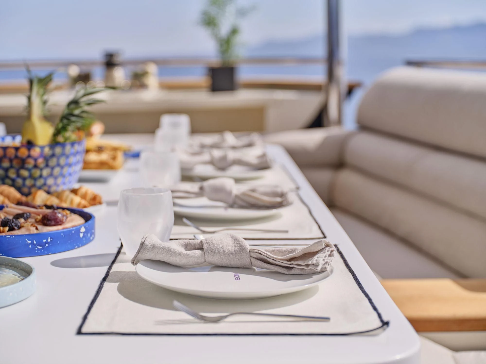 a table with plates and glasses on it aboard BEYOND Yacht for Charter