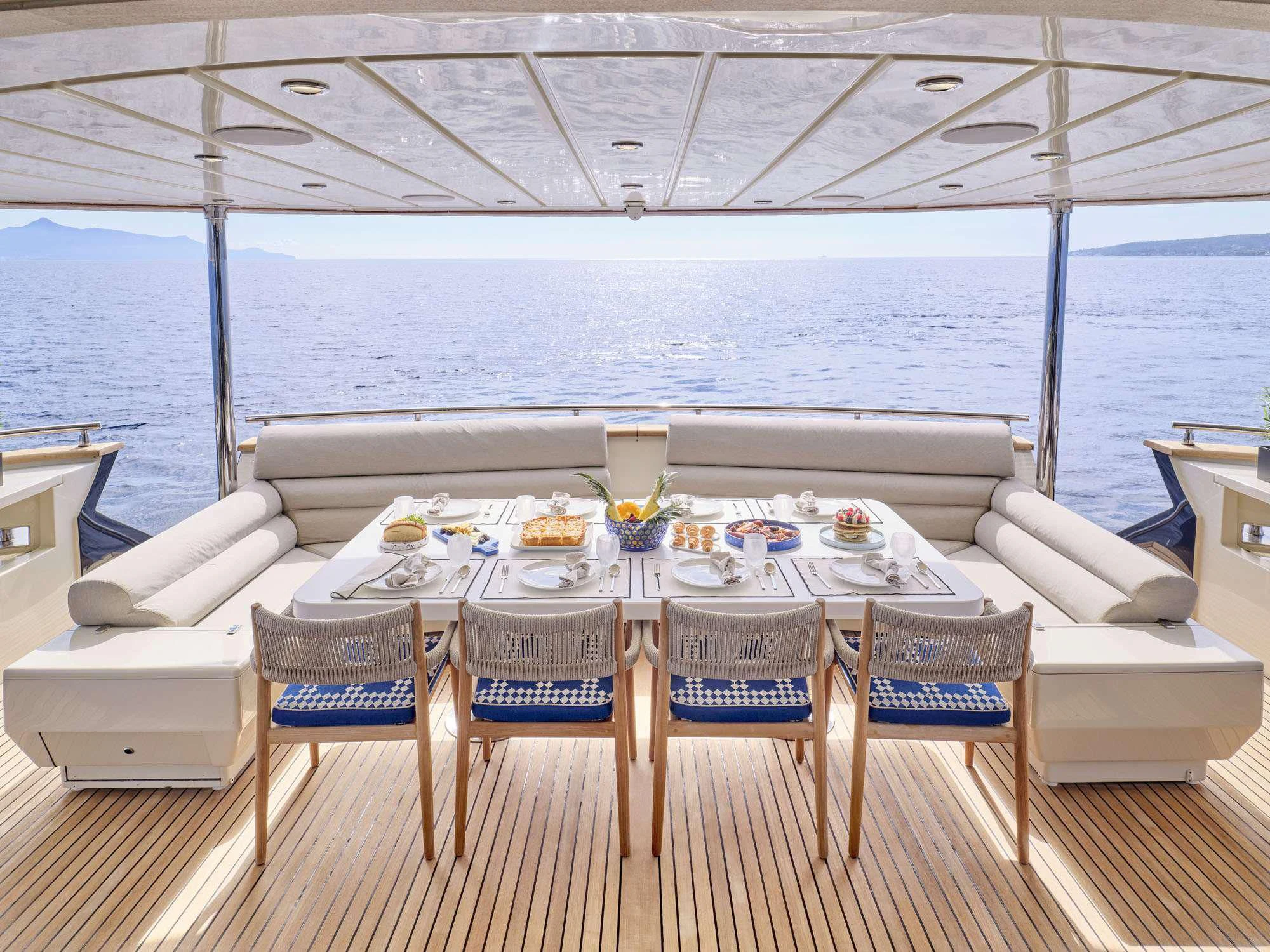 a table set for a meal on a deck overlooking the ocean aboard BEYOND Yacht for Charter