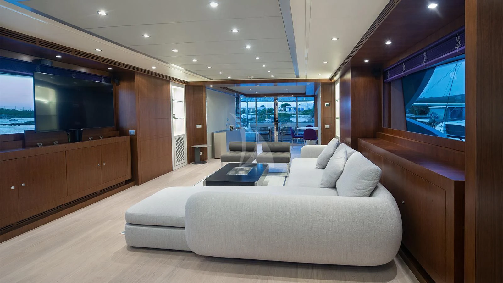 a room with a couch and a tv on the wall aboard BEYOND Yacht for Charter