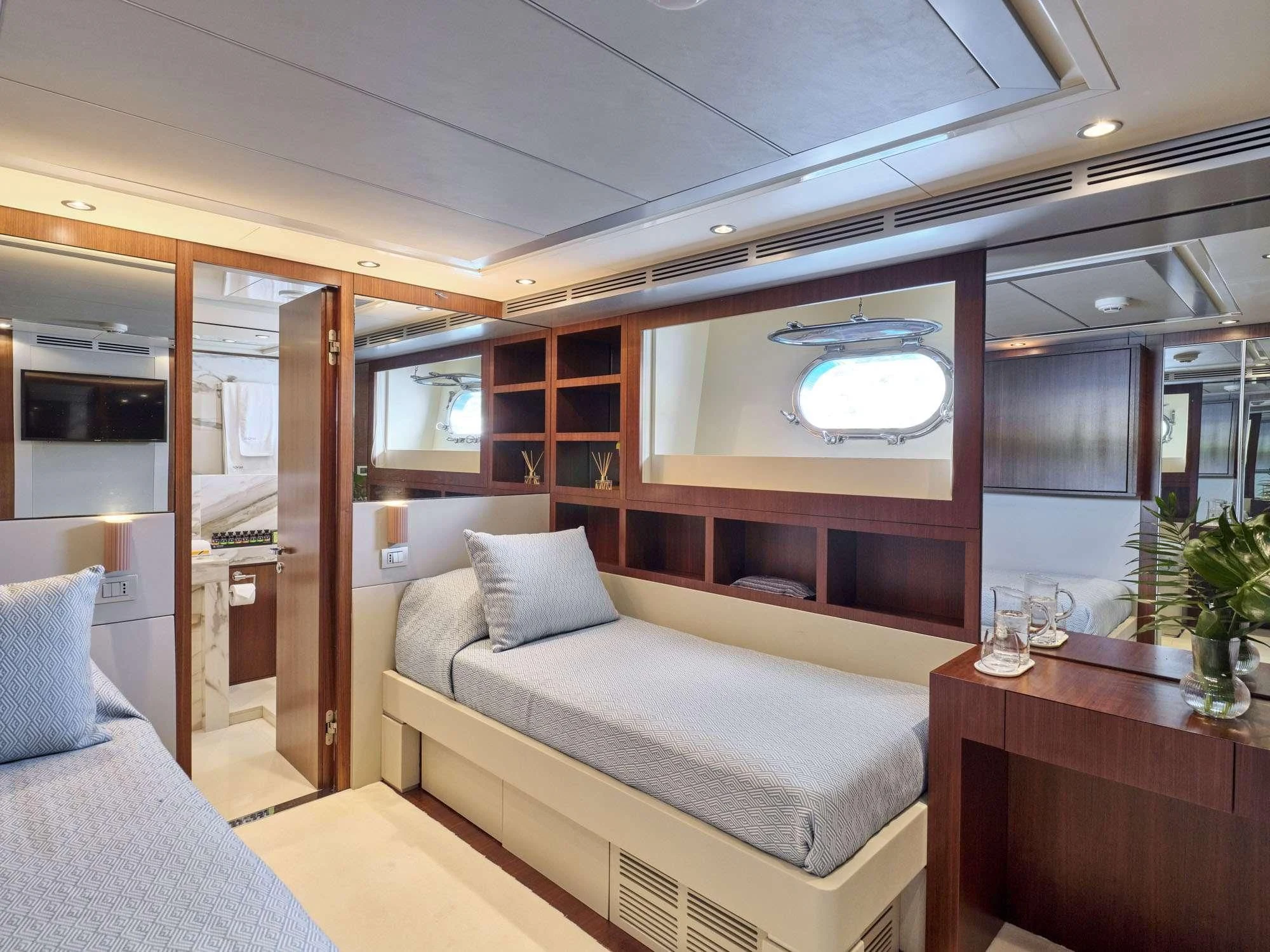 a room with a bed and a table aboard BEYOND Yacht for Charter