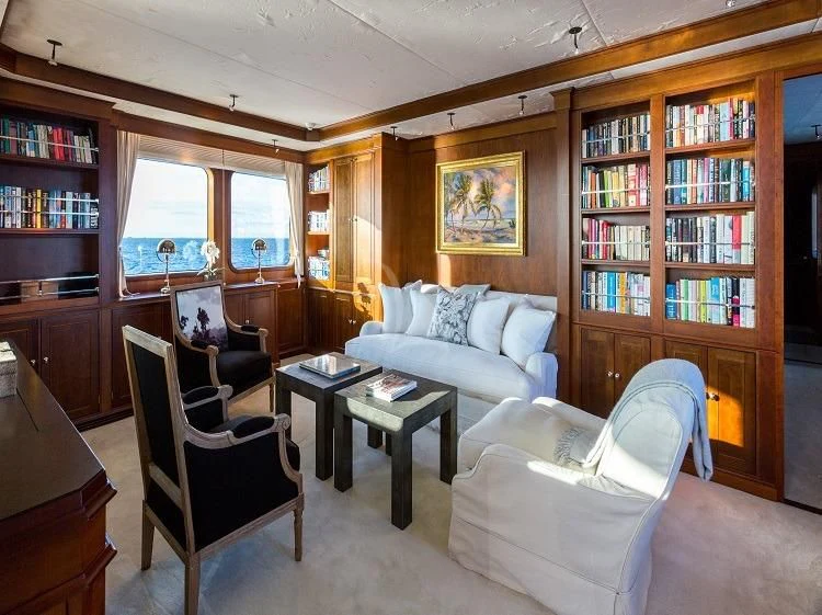 a living room with a bookcase aboard PIONEER Yacht for Sale